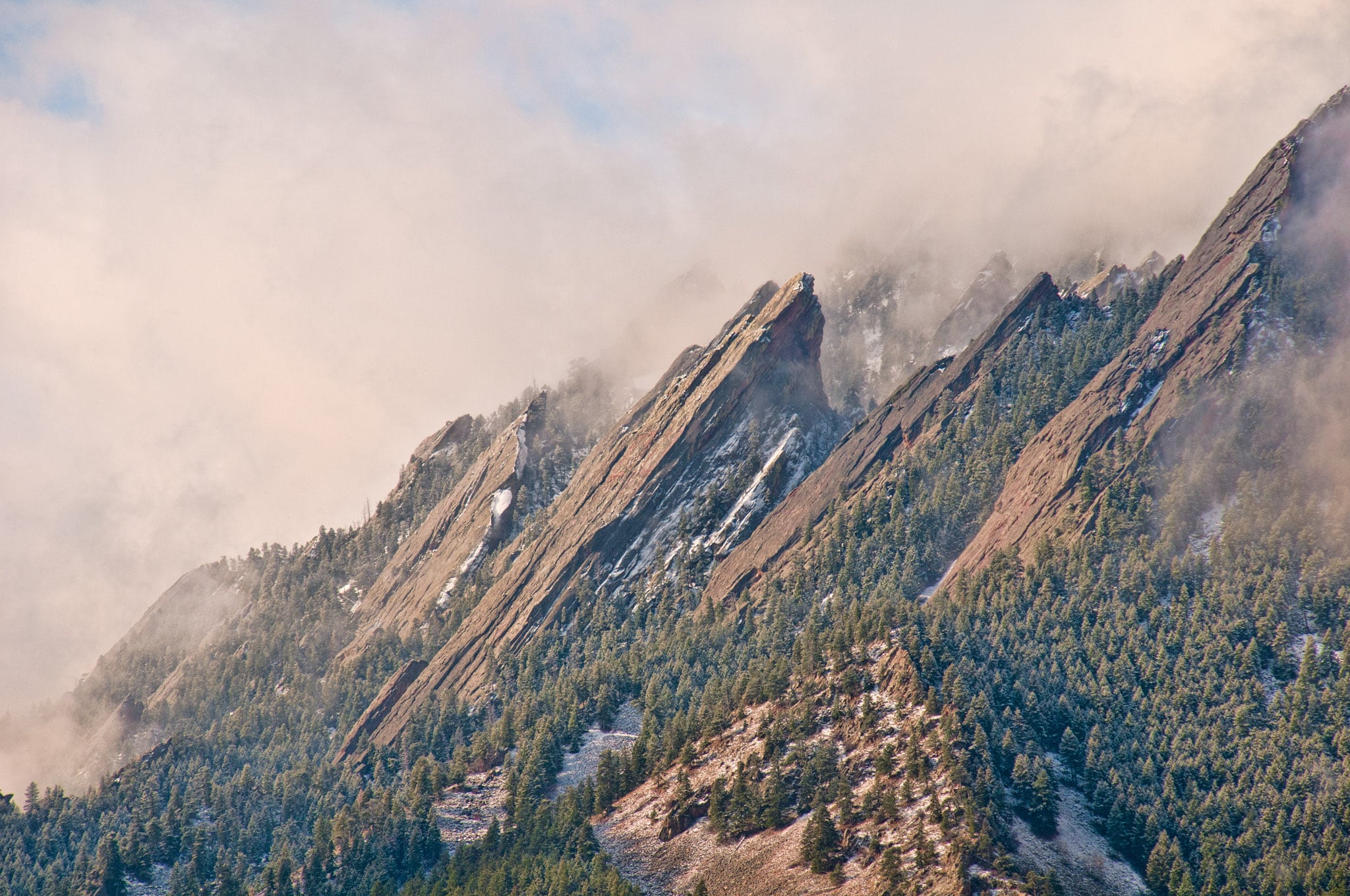 Winter clouds drape over the Flatirons west of Boulder, Colorado.