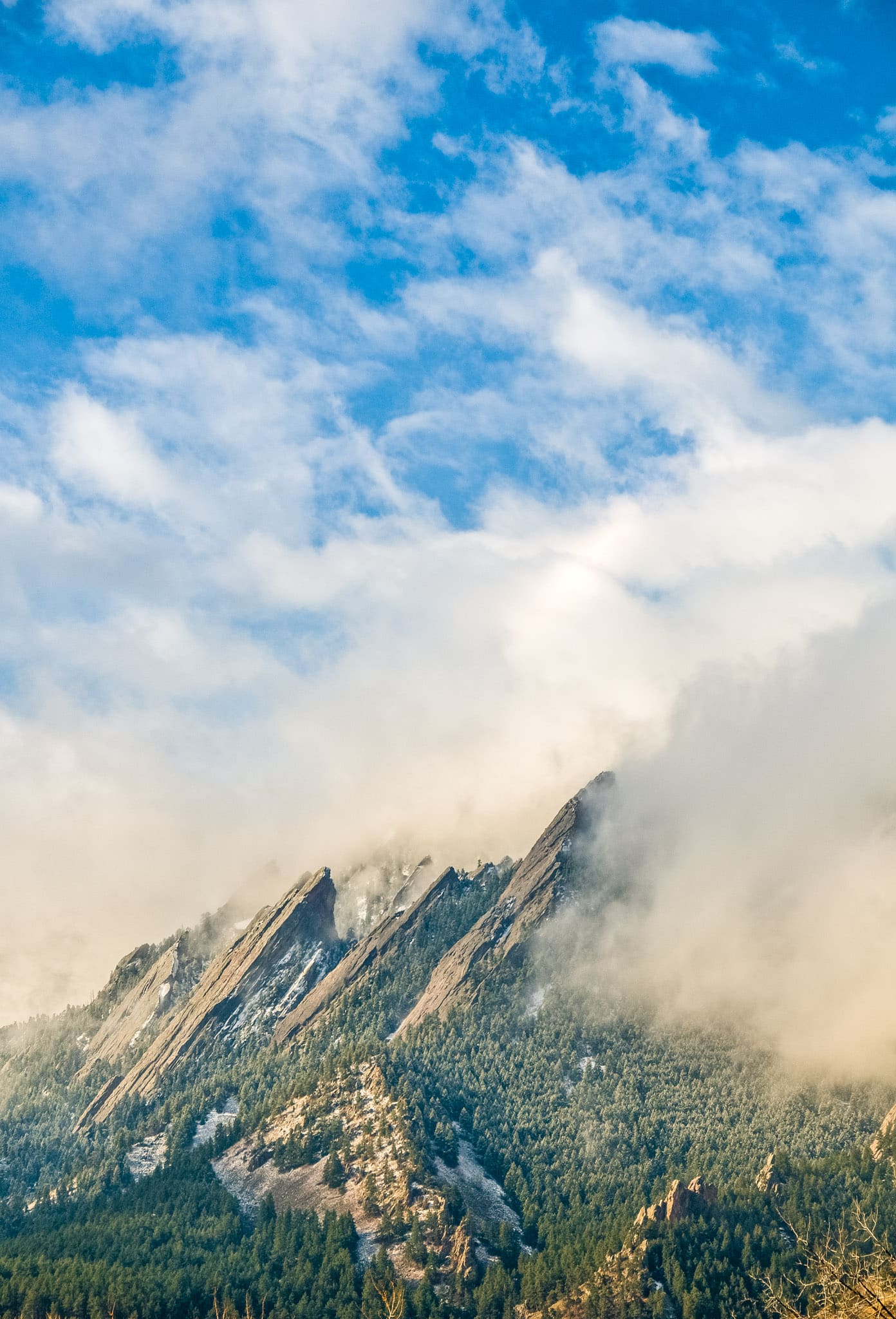 Winter clouds drape over the Flatirons west of Boulder, Colorado.