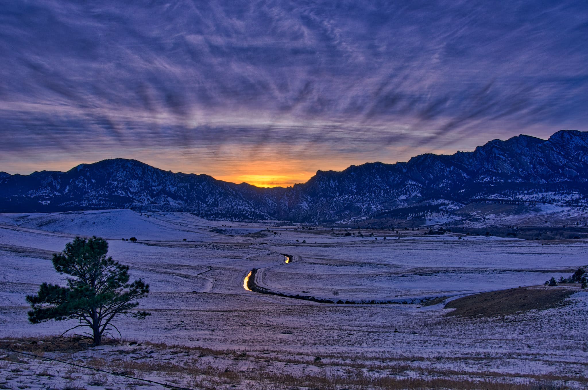 Setting sun with crepuscular rays over Eldorado Canyon in the Front Range of the Rocky Mountains near Boulder, Colorado.