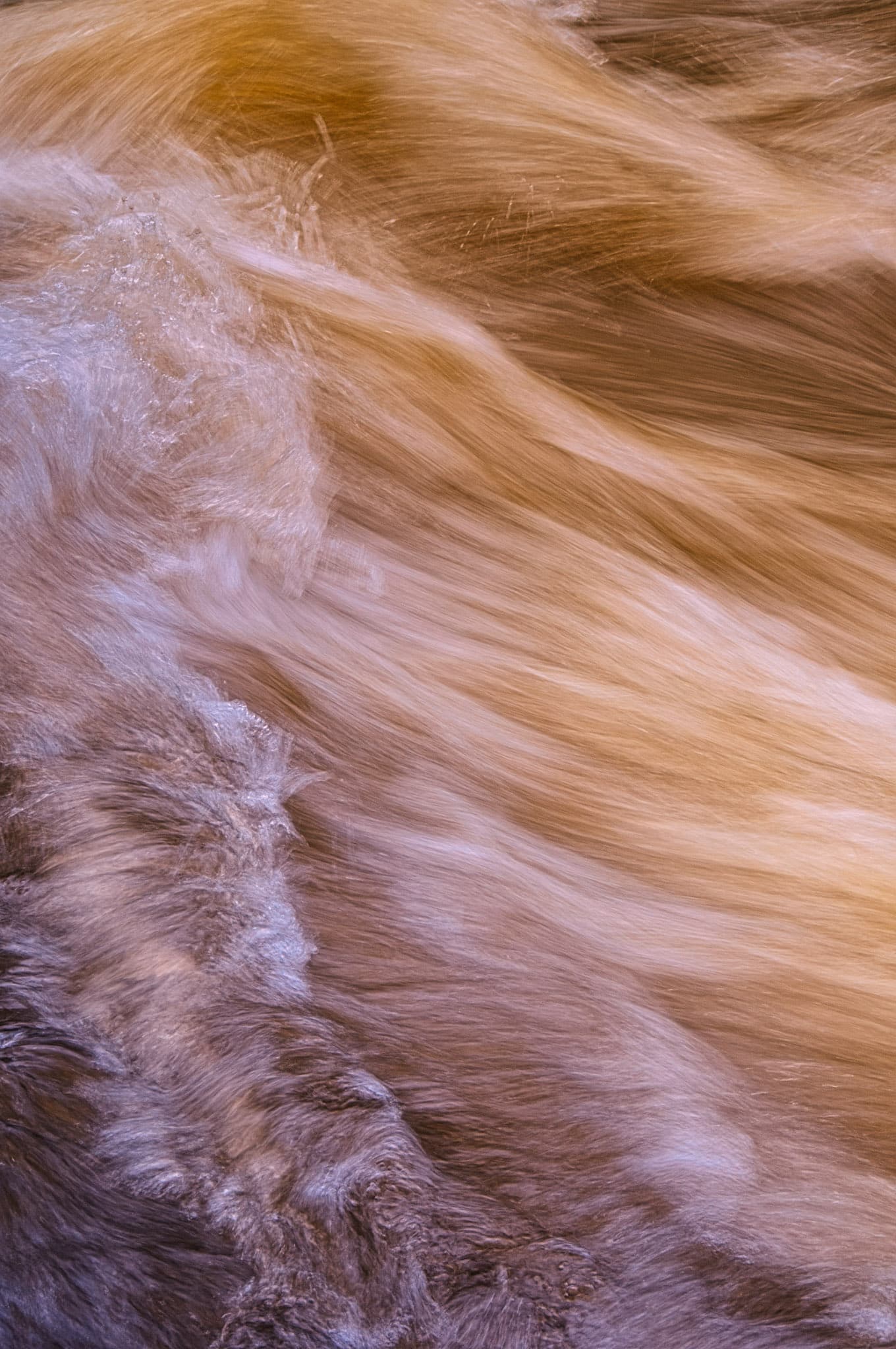 Summer rains cause Boulder Creek to flow swiftly, This is a long exposure closeup of the flowing water.