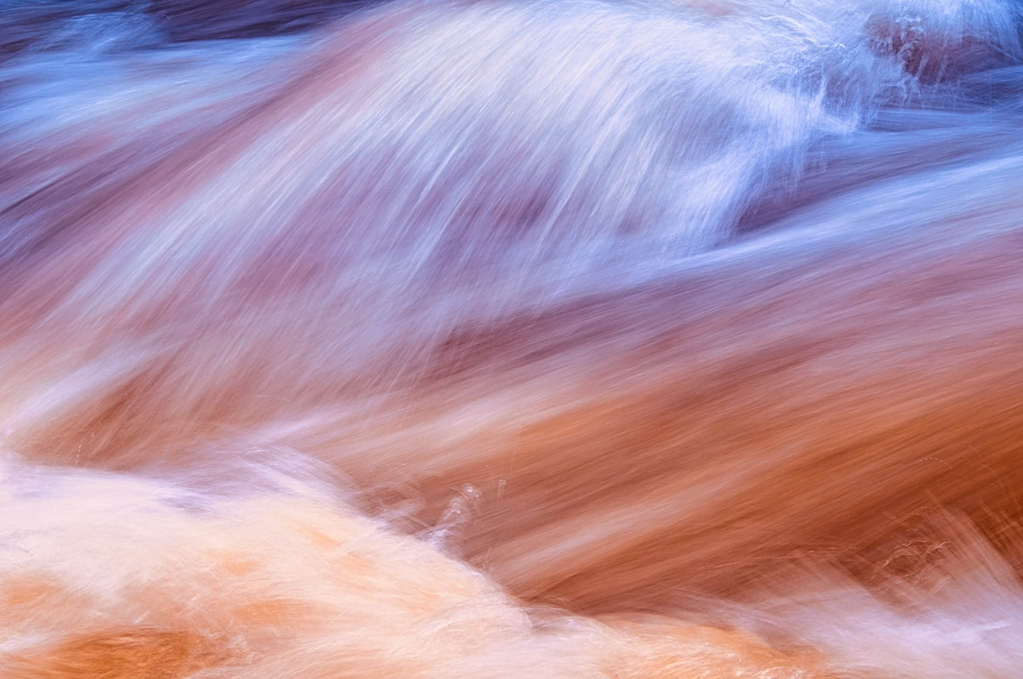 Summer rains cause Boulder Creek to flow swiftly, This is a long exposure closeup of the flowing water.