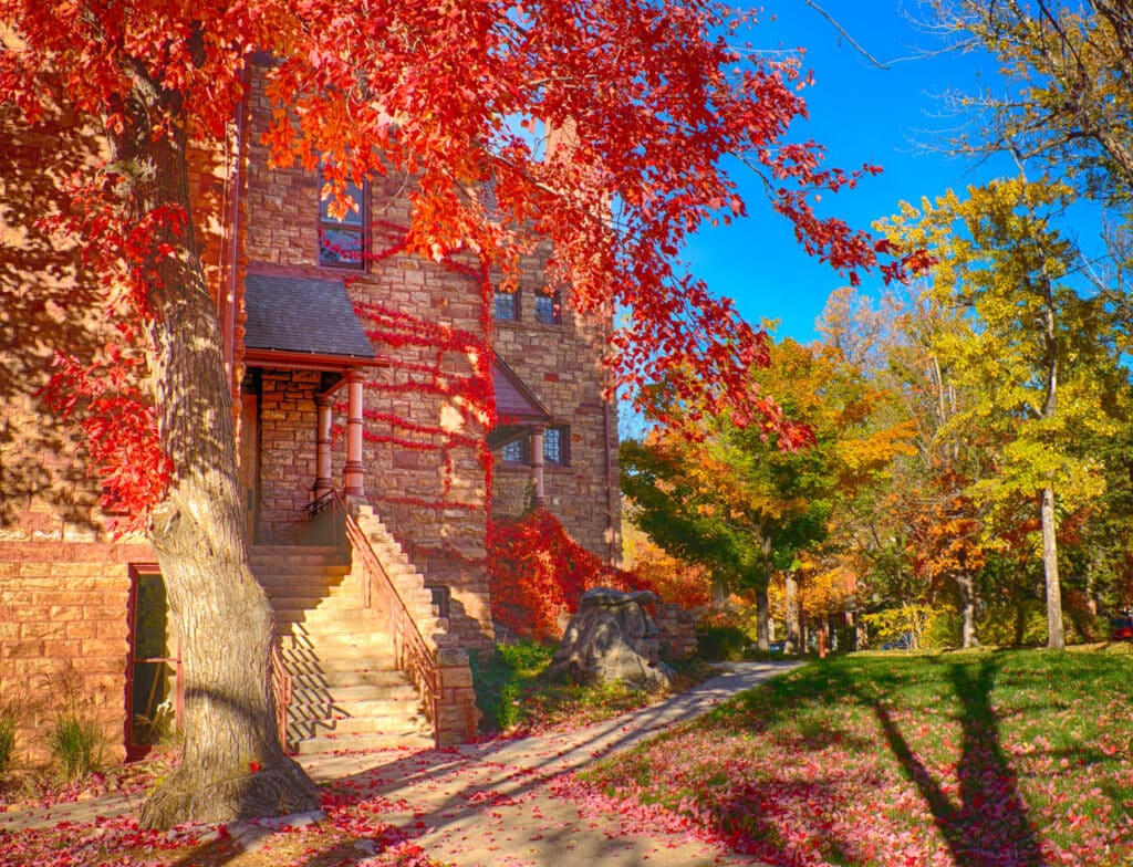 Maple trees and Virginia Creeper turn brilliant red in the fall in Mapleton Hill Neighborhood in Boulder, Colorado.