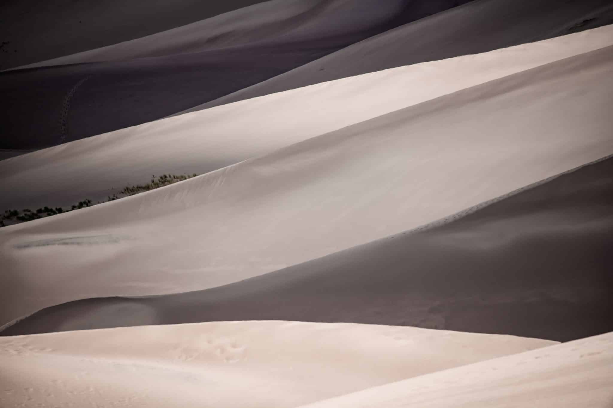 Partly cloudy skies cause interesting patterns of light and shadow on the sand dunes at Great Sand Dunes National Park and Preserve near Alamosa, Colorado.