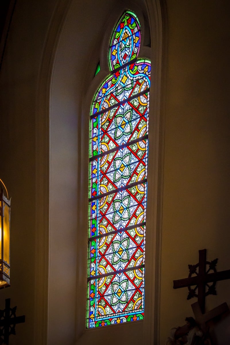 The style of the stained glass windows in the Loretto Chapel support the neo-Gothic architecture of this building.