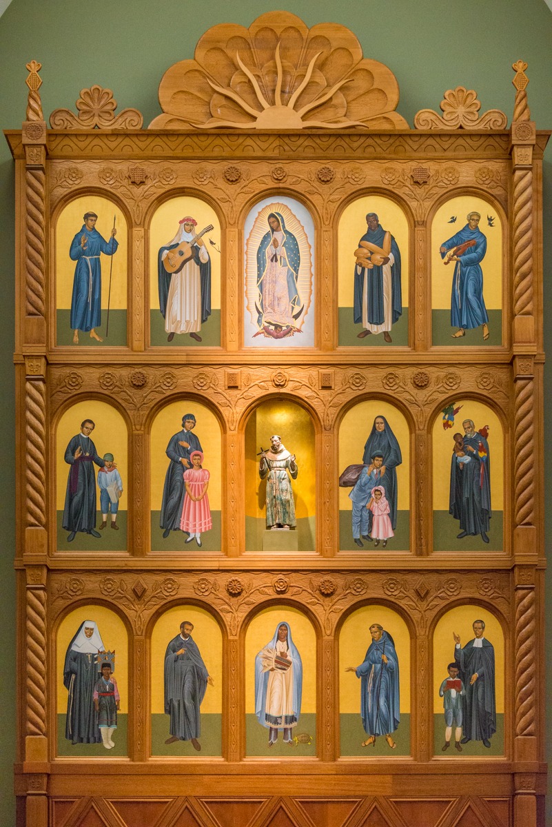 The huge altar screen (reredos) in the sanctuary is by Robert Lentz and depicts the Saints of the Americas. The older statute of St. Francis of Assisi in the center of the screen is from the old 1717 parroquía.