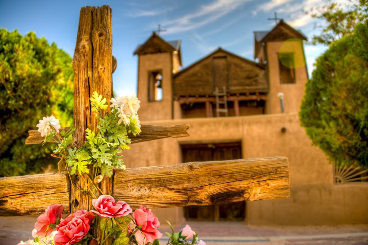 A close-up of a decorated wooden cross in the forecourt of El Santuario de Chimayo, Chimayo, New Mexico.