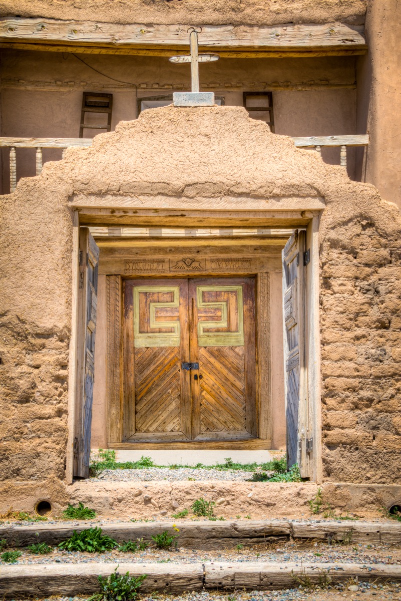 A close-up view through the arched gateway toward the double wooden doors of the San Jose de Gracia church. The San Jose de Gracia Church, also known as Church of Santo Tomas Del Rio de Las Trampas, is a historic church on the main plaza of Las Trampas, New Mexico.