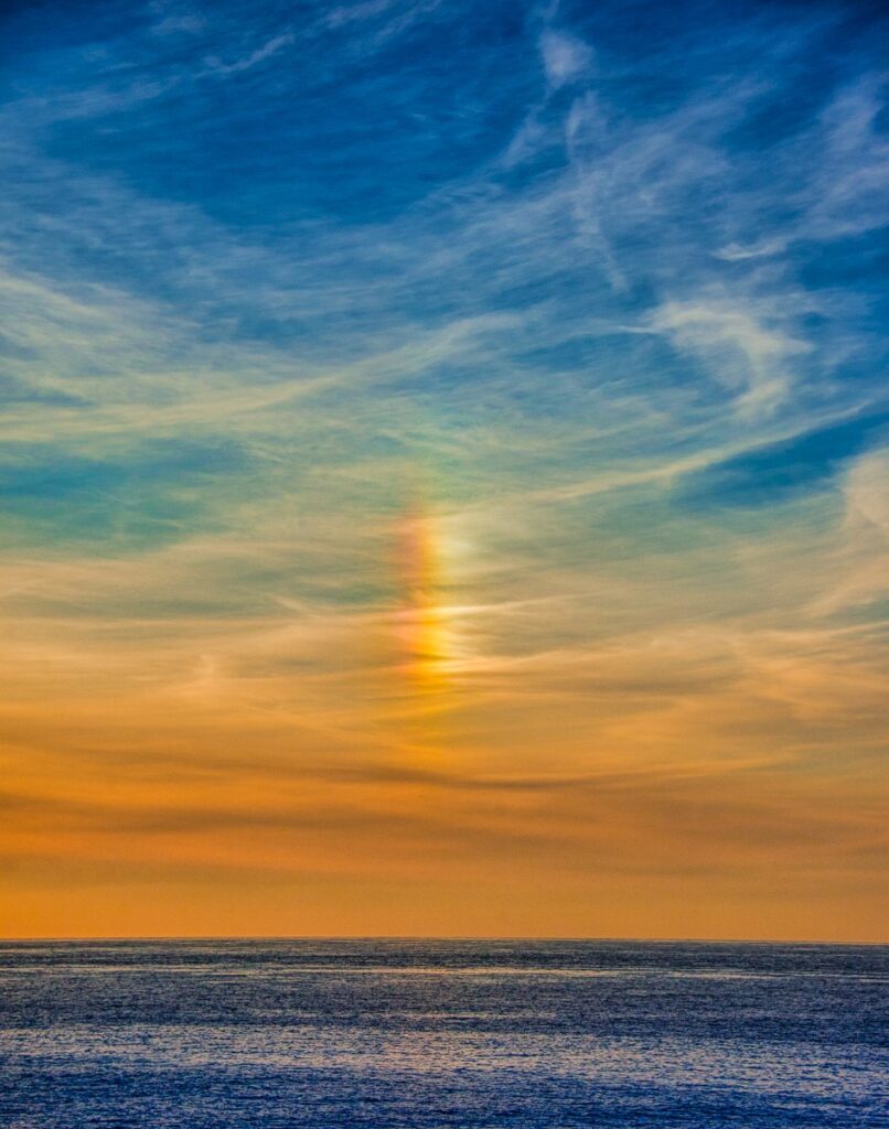 A sun dog is visible above Fistal Bay near Newquay in Cornwall, England.