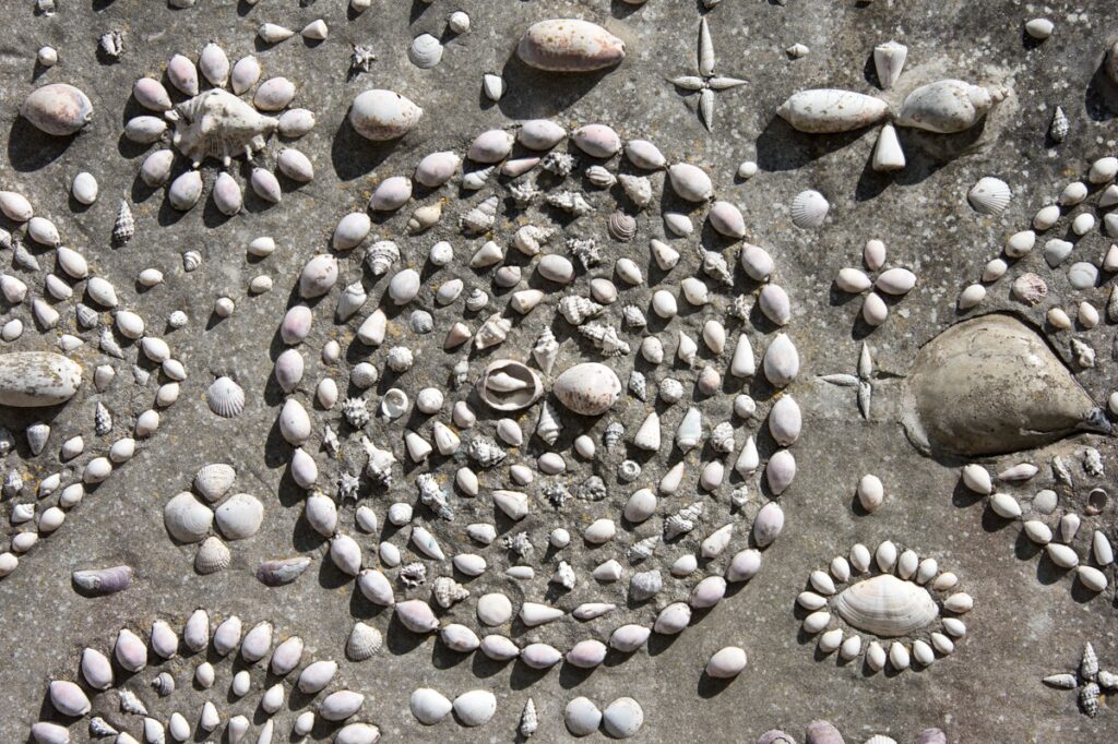This is a detail view of Shell House in the Warren area of Polperro, Cornwall, England. The wall of the cottage was decorated in this manner over a five year period in the 1930s by a retired sailor, Samuel Puckey. Many of the shells came from Mr Puckey's travels around the world during his days at sea.