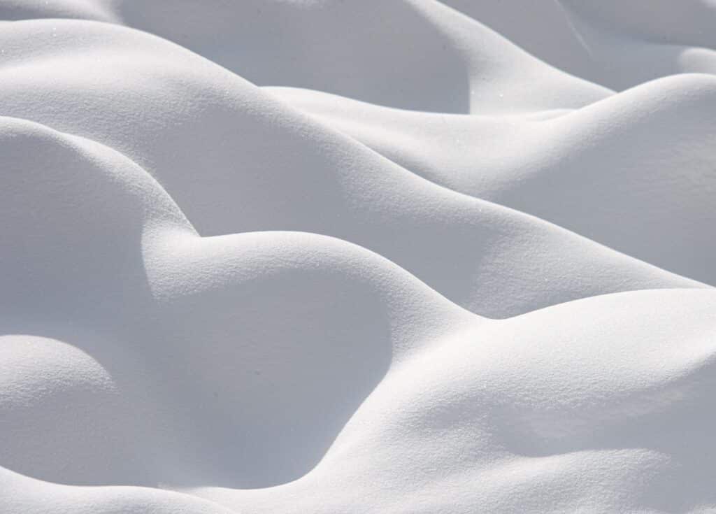 This is a close-up of rounded piles of snow that look pillowy and soft in Yellowstone National Park, Wyoming.