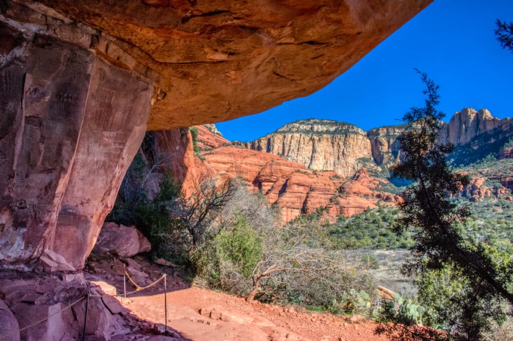 The surrounding red and buff sandstone cliffs are visible from under the overhang of an alcove at Palatki Heritage Site near Sedona, Arizona.