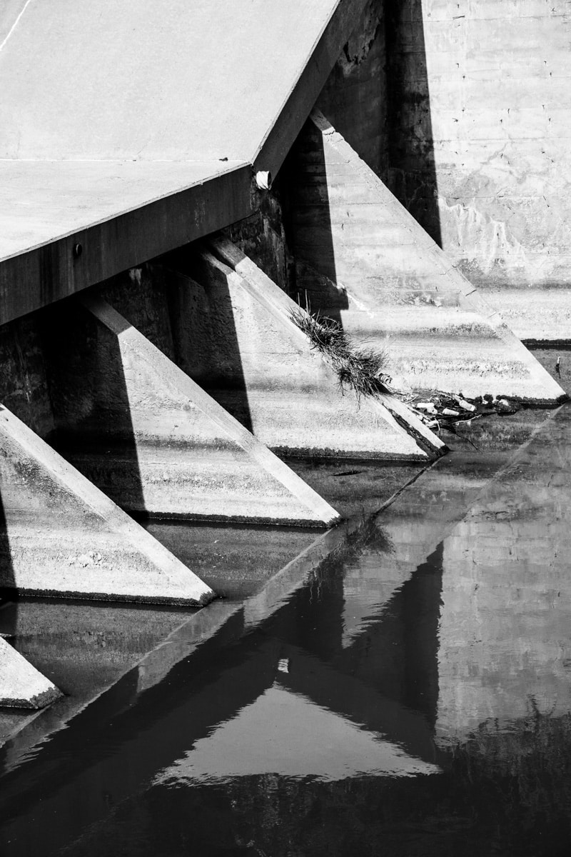 Dam piers and water create an abstract composition at Lake Scott State Park near Scott City, KS.