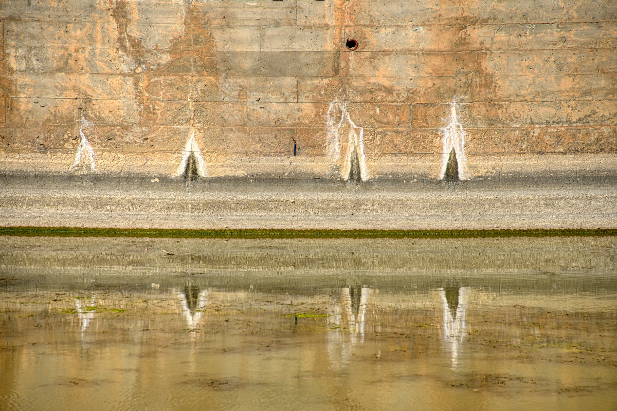 Water stains on a dam are reflected in the water at Lake Scott State Park near Scott City, KS.