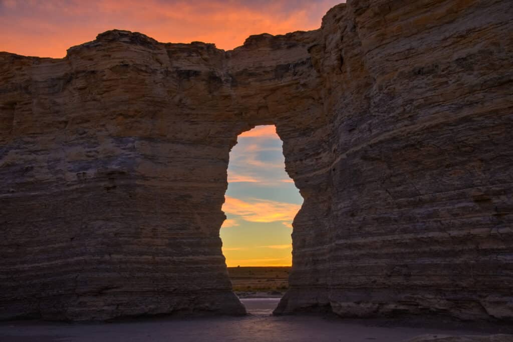 Sunrise colors shine through a window in one of the formations at Monument Rocks near Oakley, KS.
