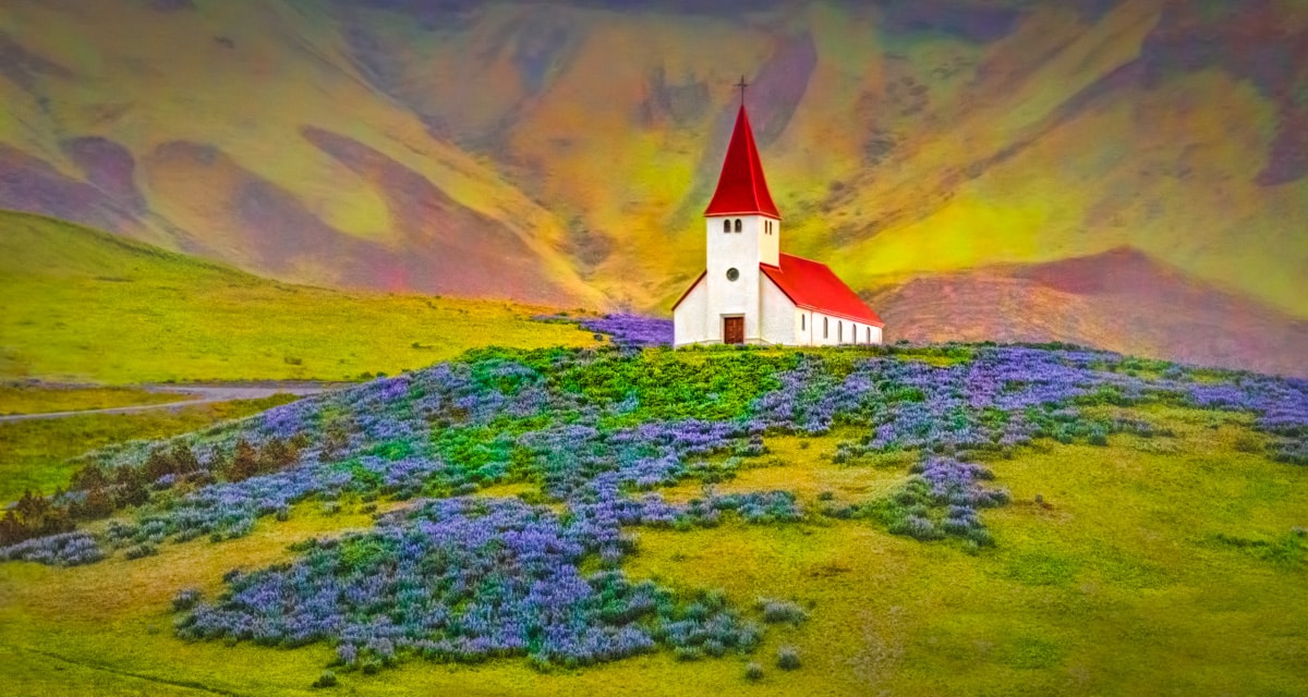 On a rainly afternoon, the church at Vik, sitting above the town in a field of lupine with a background of volcanic hills, catches a little afternoon sunlight.
