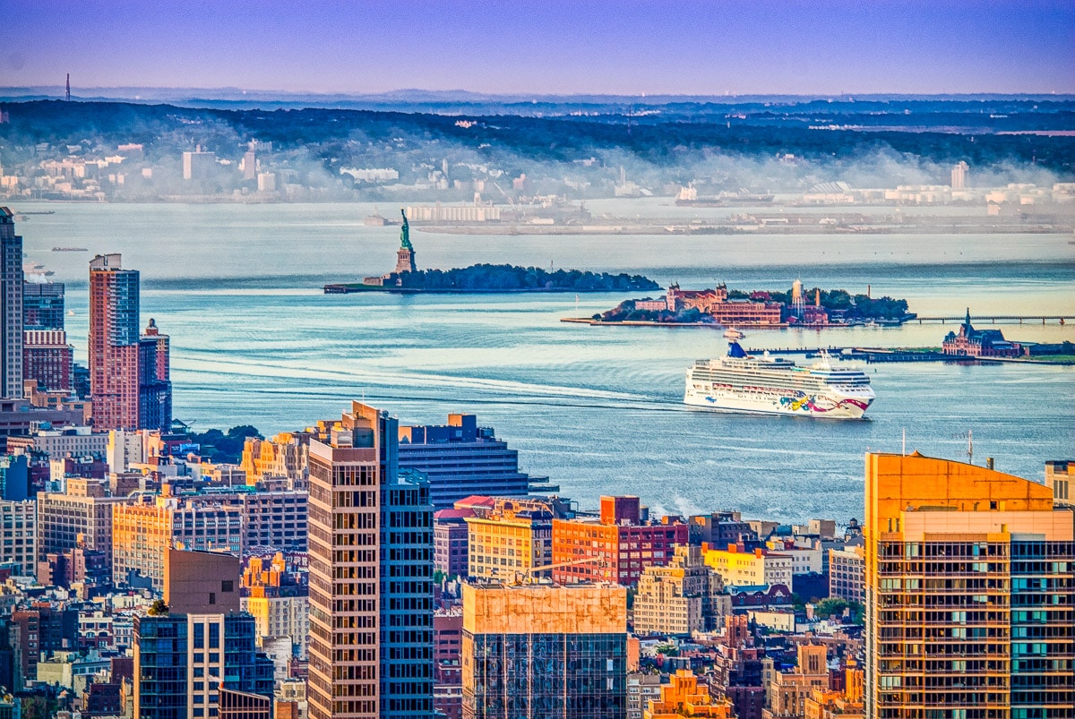 A sunrise view across the harbor to Ellis Island and the Statue of Liberty from 30 Rockefeller Center in New York City.