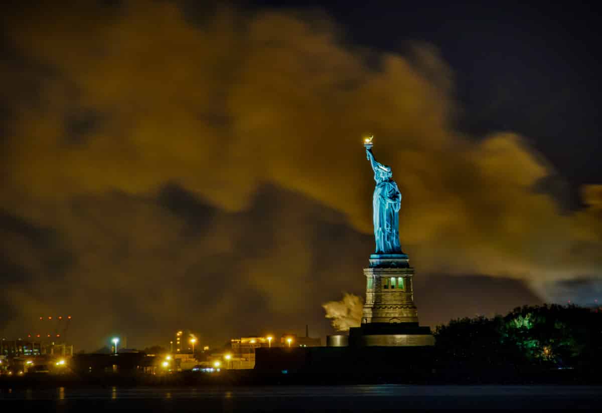 A view of the Statue of Liberty with smoke from a fire wafting from behind.