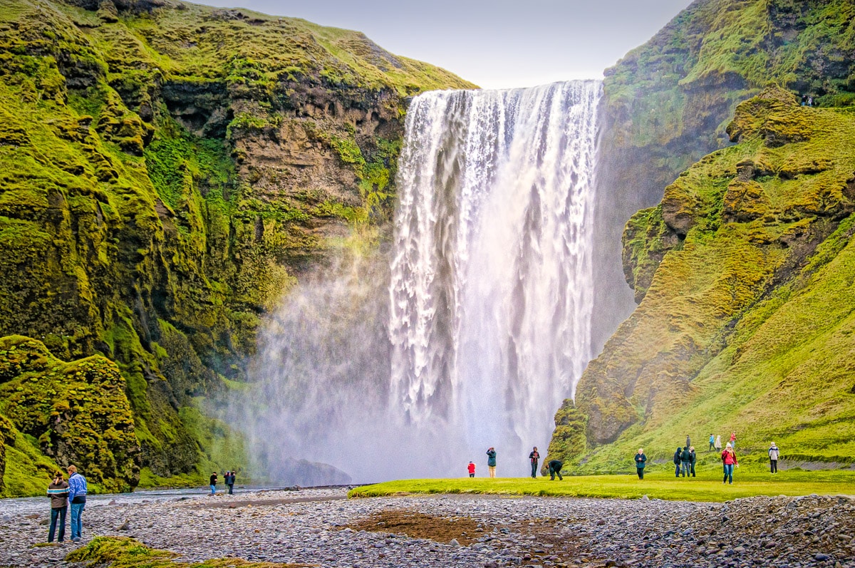 This is a medium view of Skógafoss, showing both the top of the falls and the base, where the plunging water creates billows of mist. Skógafoss is a waterfall in southern Iceland, along Route 1. It's source is runoff from the glacier Eyjafjallajökull and the glacier Myrdalsjokull.