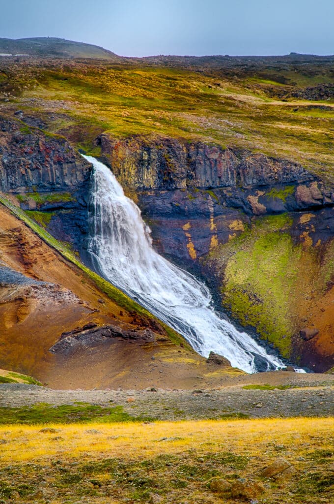This waterfall, the Rjúkandi, flows down a sloping valley and over a lava ledge. Then, it spreads out over a 45-degree lava slope, running into the JOKULSA a BRU, known locally as the Jokla. It is located off Route 1, northwest of Egilsstaðir.