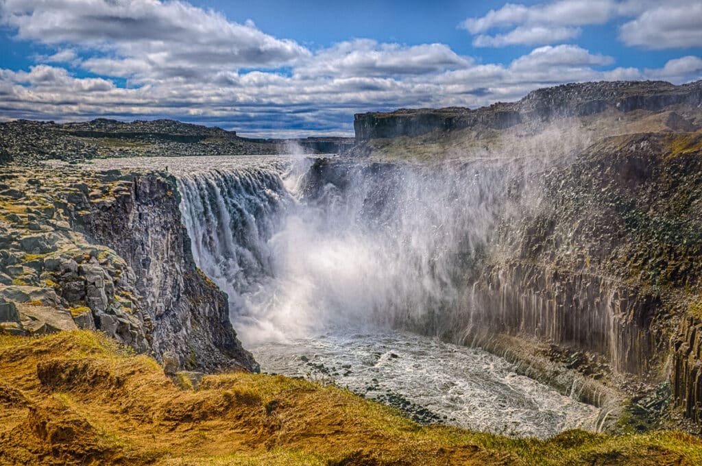 Billows of spray rise into the air above the plunge pool of Dettifoss, the most powerful waterfall in Europe, just south of Jökulárgljúfur National Park in Iceland.