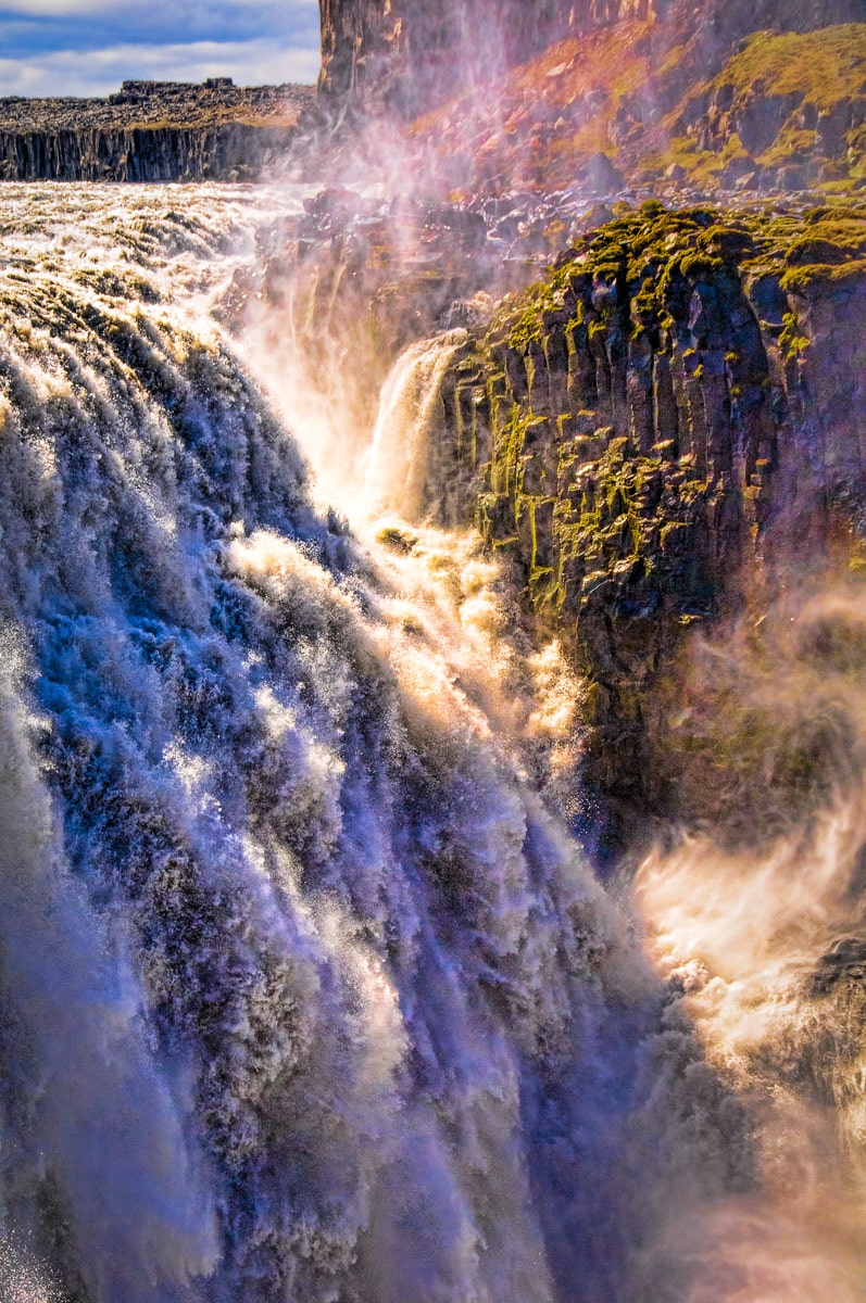 The waters of Dettifoss rage over a lava cliff, creating swirling spray and raucous thunder.