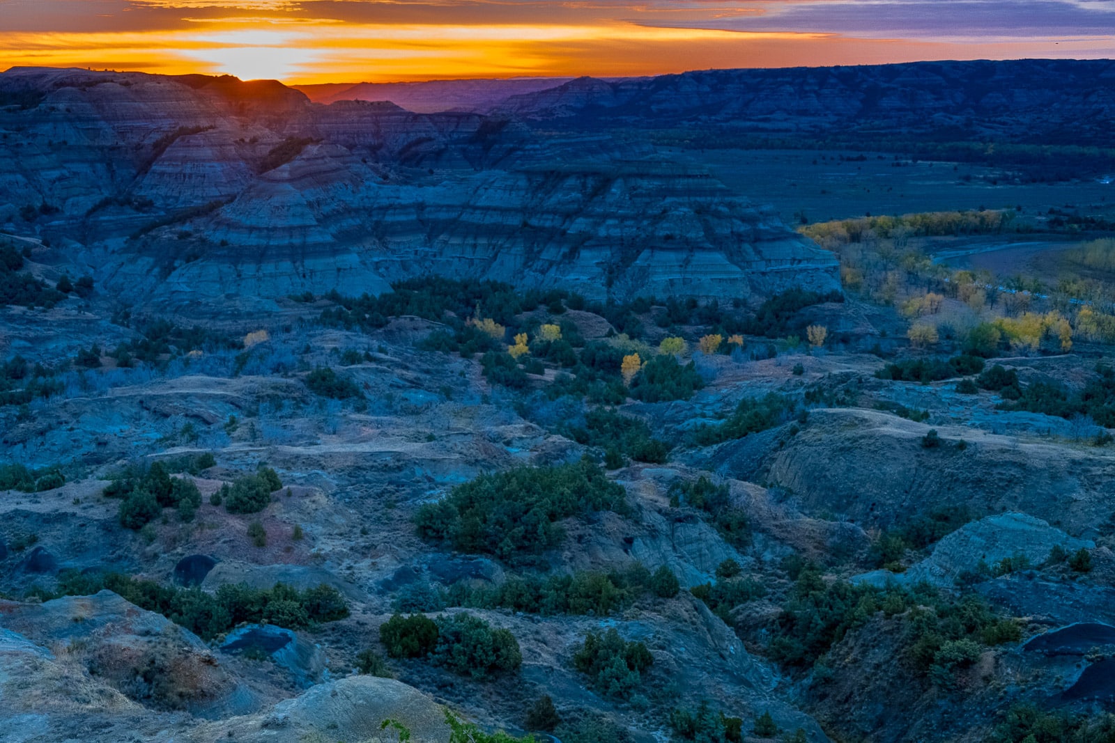 Looking across the badlands to the Little Missouri River at sunrise in the North Unit of Theodore Roosevelt National Park in North Dakota.